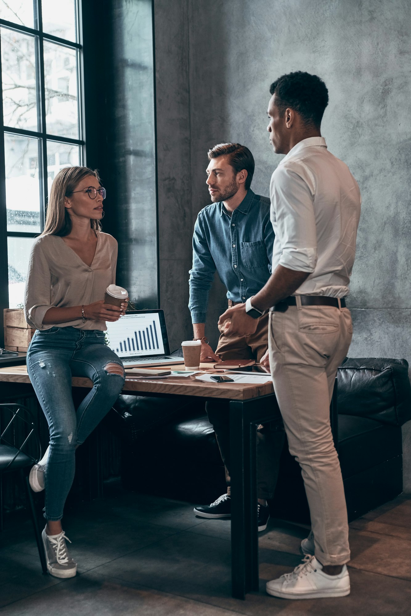 Group of young people in smart casual wear discussing business while working in the office